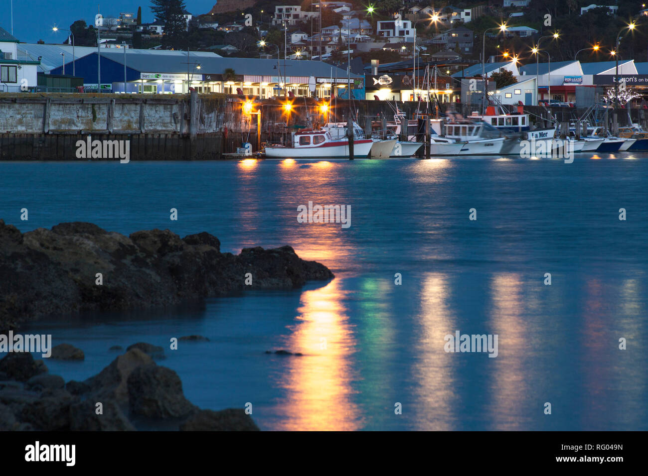 Le luci del molo a Napier, Nuova Zelanda, riflettono i colori in acqua su tutta la baia. Foto Stock