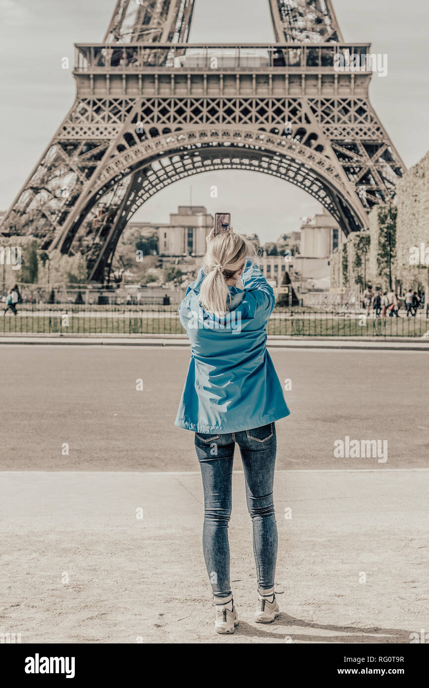 Ragazza turistica prendendo immagini della Torre Eiffel. Foto Stock