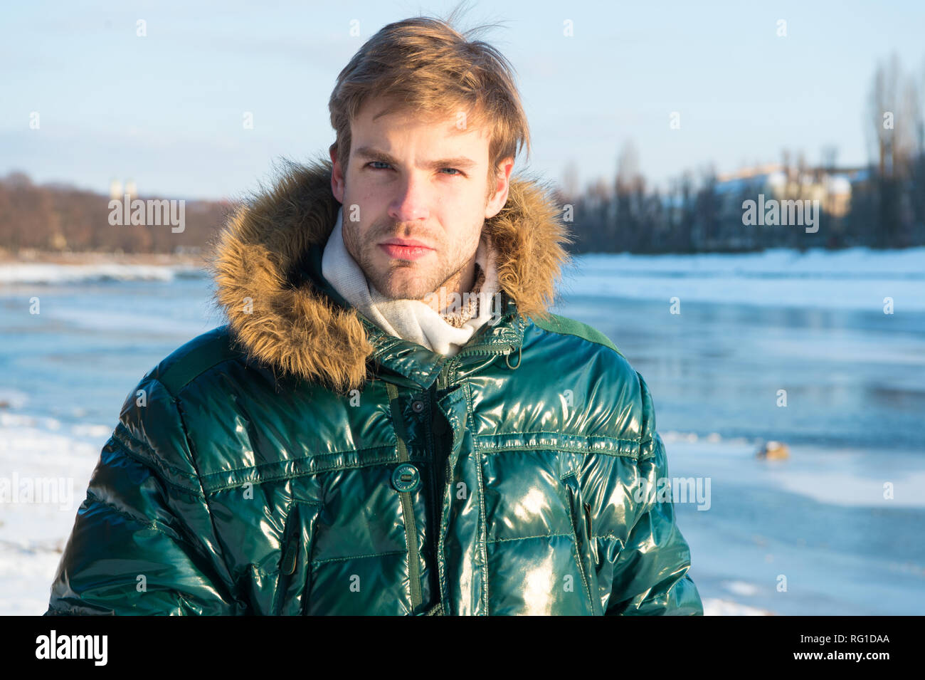 Abito invernale. Uomo Barbuto stand giacca calda innevate sullo sfondo  della natura. Hipster inverno abito moda. Guy indossare giacca con  cappuccio sulla gelida giornata invernale. Resistente al vento vestiti.  Inverno elegante menswear