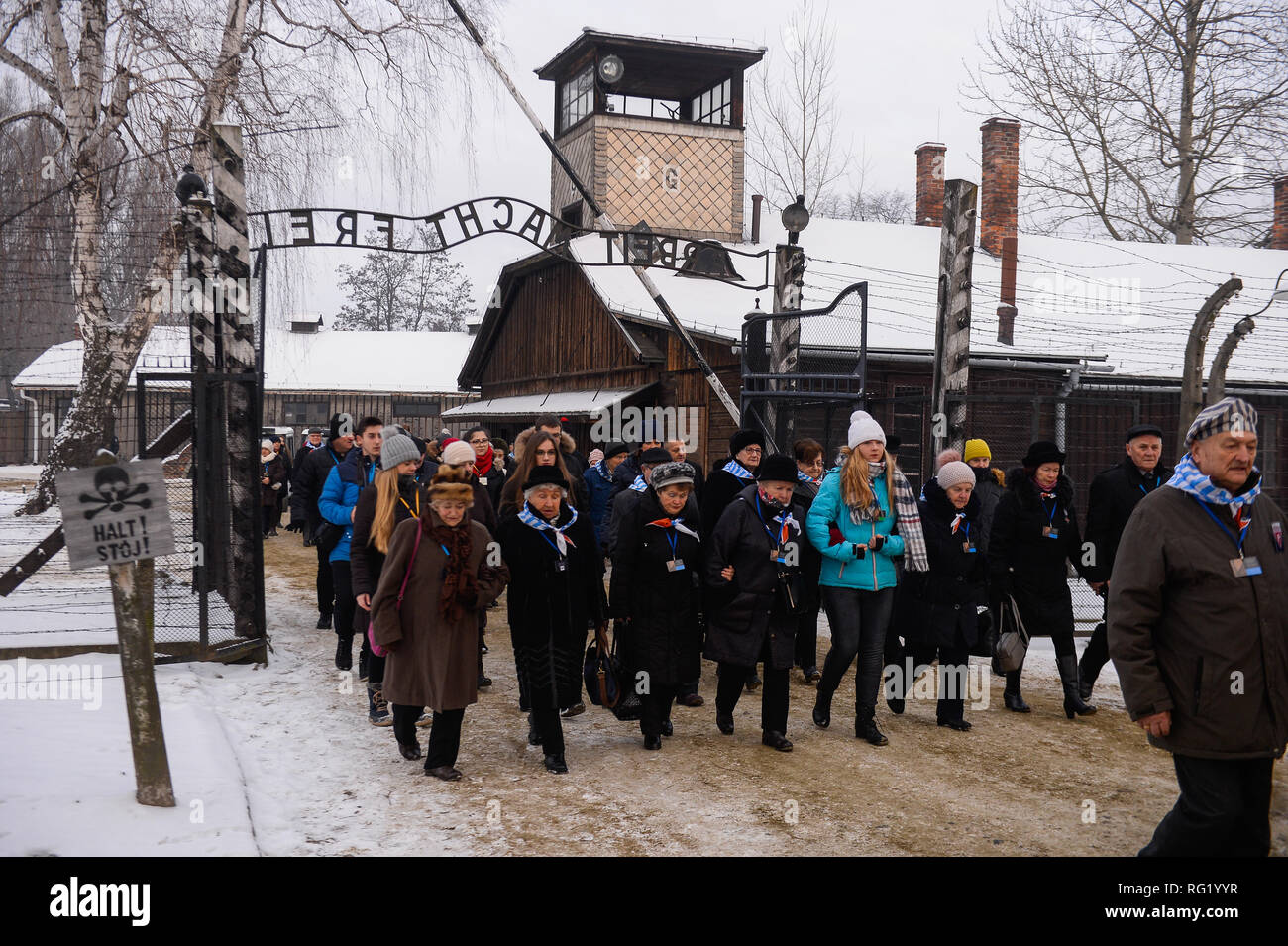 I sopravvissuti di Auschwitz sono visto che attraversa la famosa porta presso il nazista tedesco la morte di Auschwitz-Birkenau camp durante la 74anniversario della liberazione di Auschwitz. Foto Stock