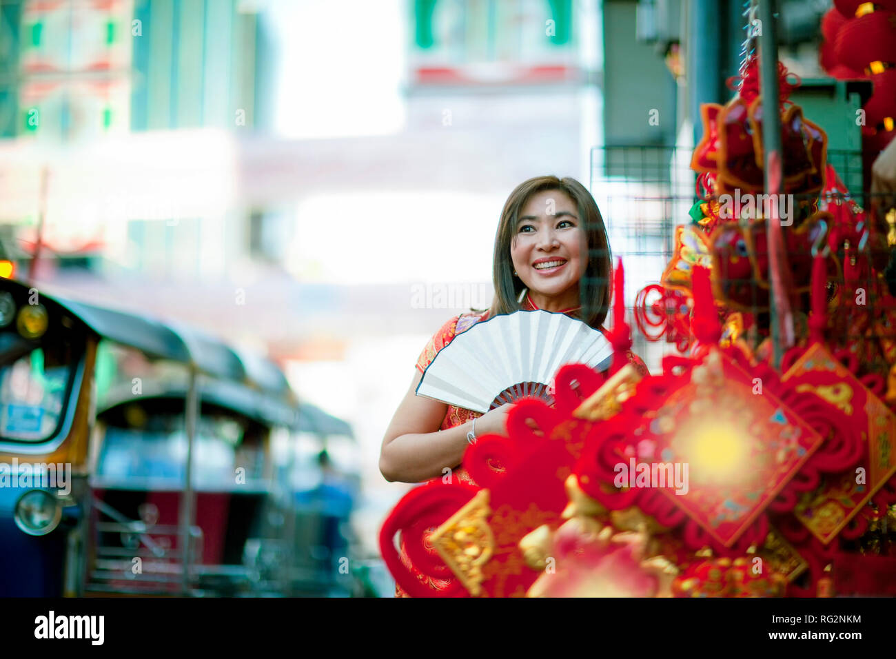 Donna asiatica che indossa la tradizione cinese con abiti cinesi di bamboo toothy ventola faccia sorridente in yaowarat street China town di Bangkok in Thailandia Foto Stock