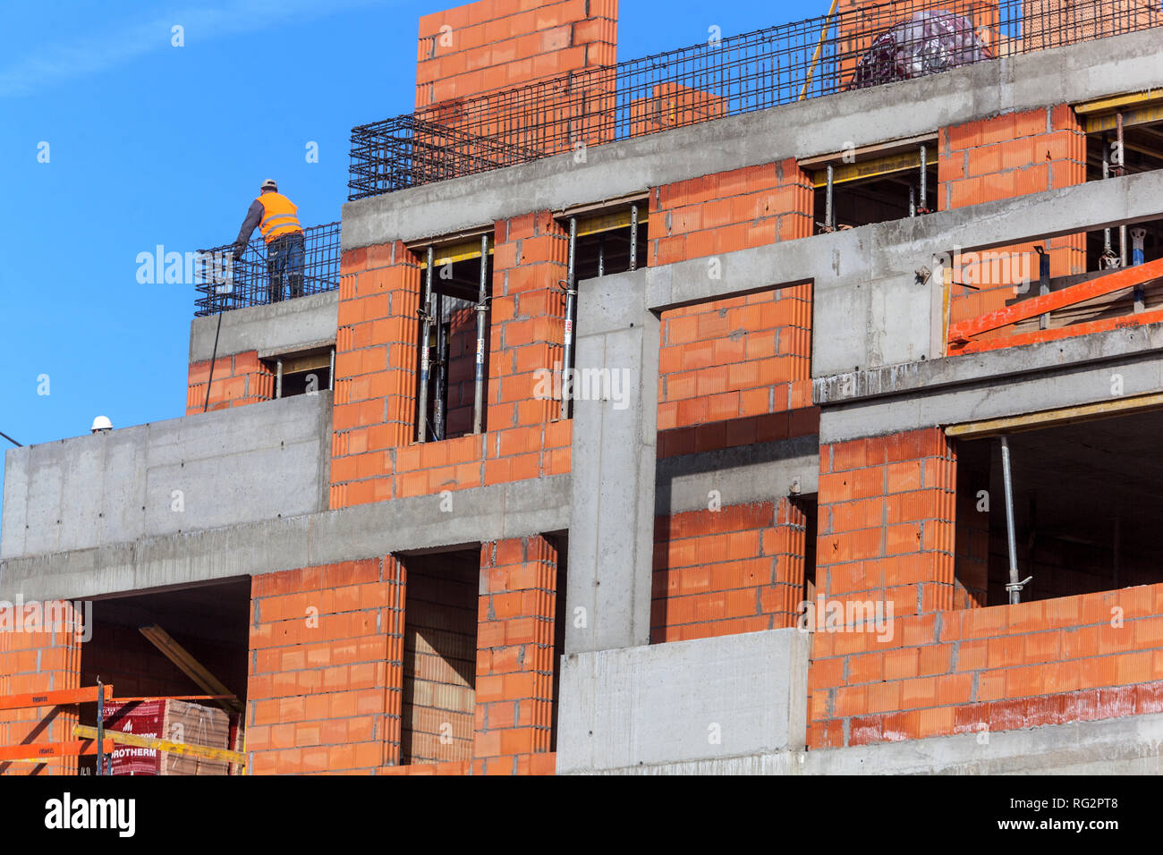 Nuovo cantiere immobiliare edificio calcestruzzo, mattoni una persona lavoratore uomo lavoratore maschio lavoro sito, Praga Repubblica Ceca Foto Stock
