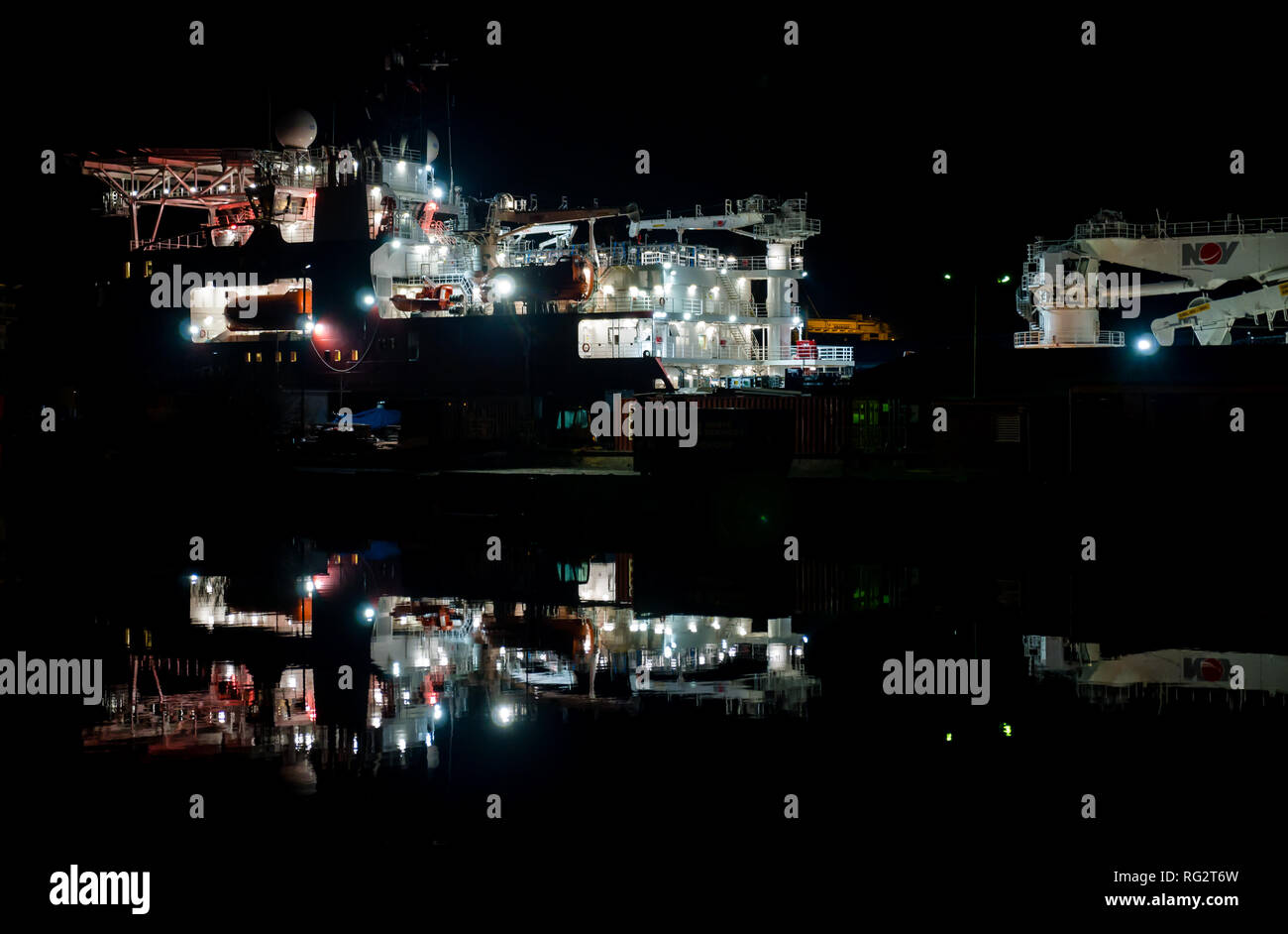 La riflessione di alimentazione olio nave nave di lavoro in acqua di notte, Leith Harbour, Edimburgo, Scozia UK Foto Stock