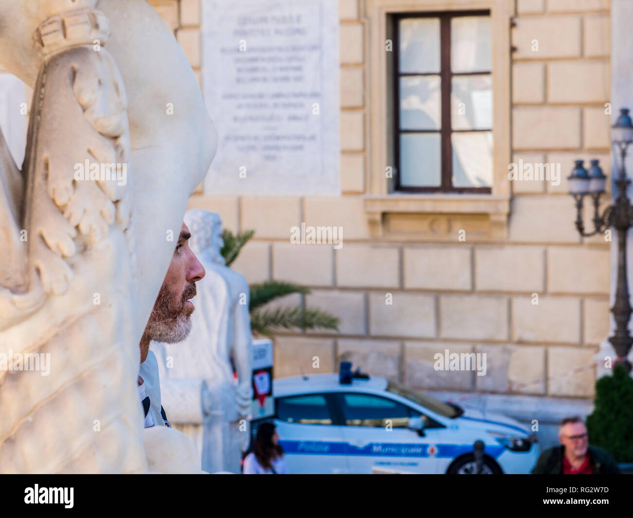 Il volto dell'uomo il peering fuori da in-tra statue, della città di Palermo, Sicilia, Italia, Europa Foto Stock