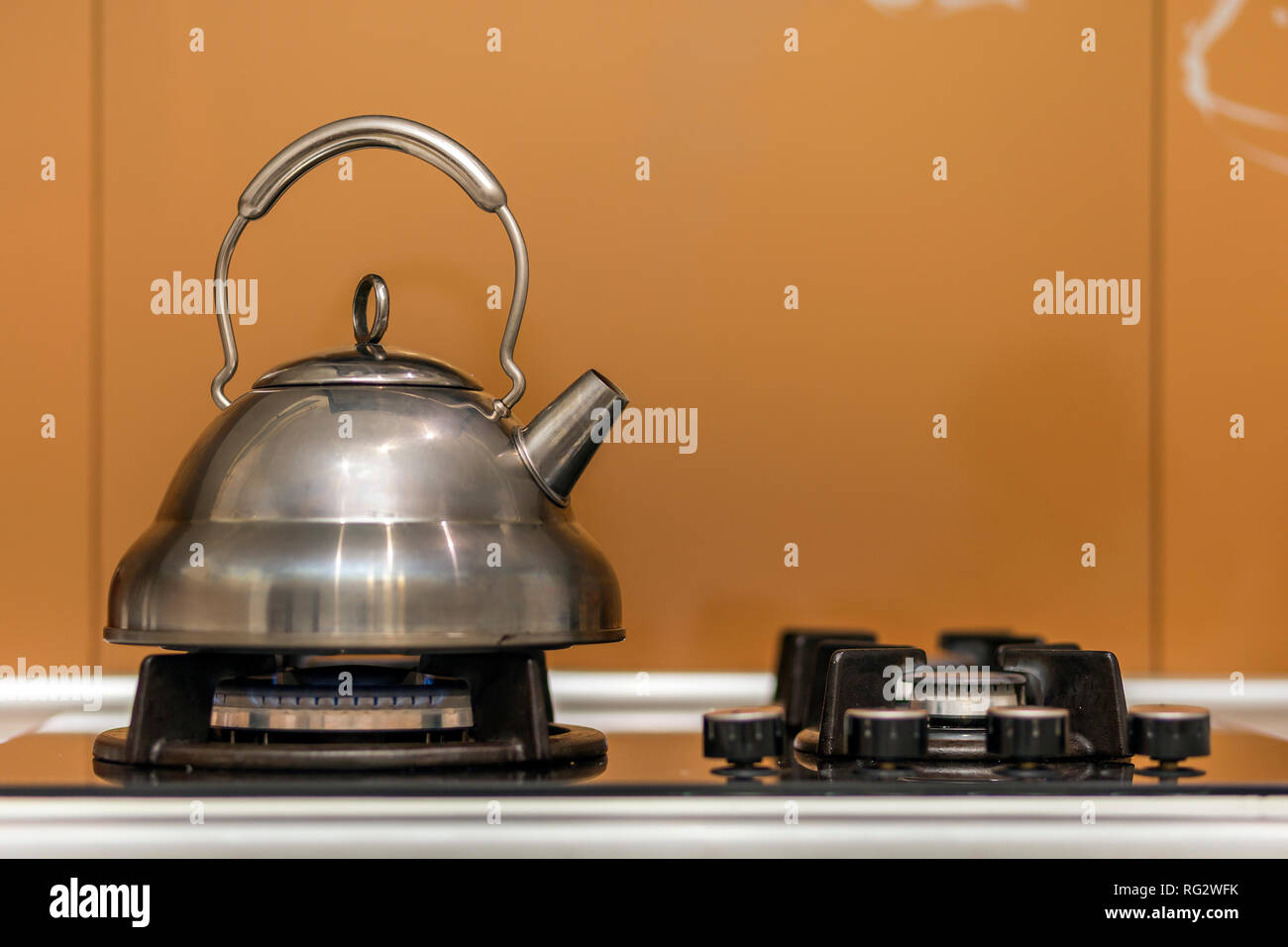 Acciaio inox lucido bollitore teiera con acqua bollente sul fornello a gas  su cucina copia gialla sfondo spazio Foto stock - Alamy