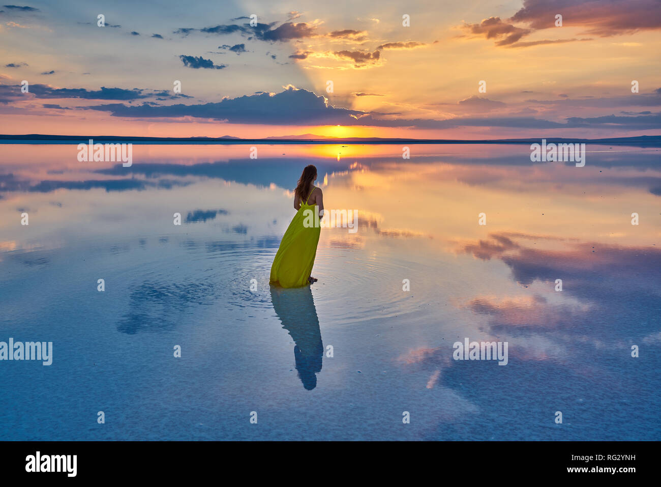 Giallo modello vestito al tramonto sul lago di sale (Tuz Gölü), Turchia. Foto Stock