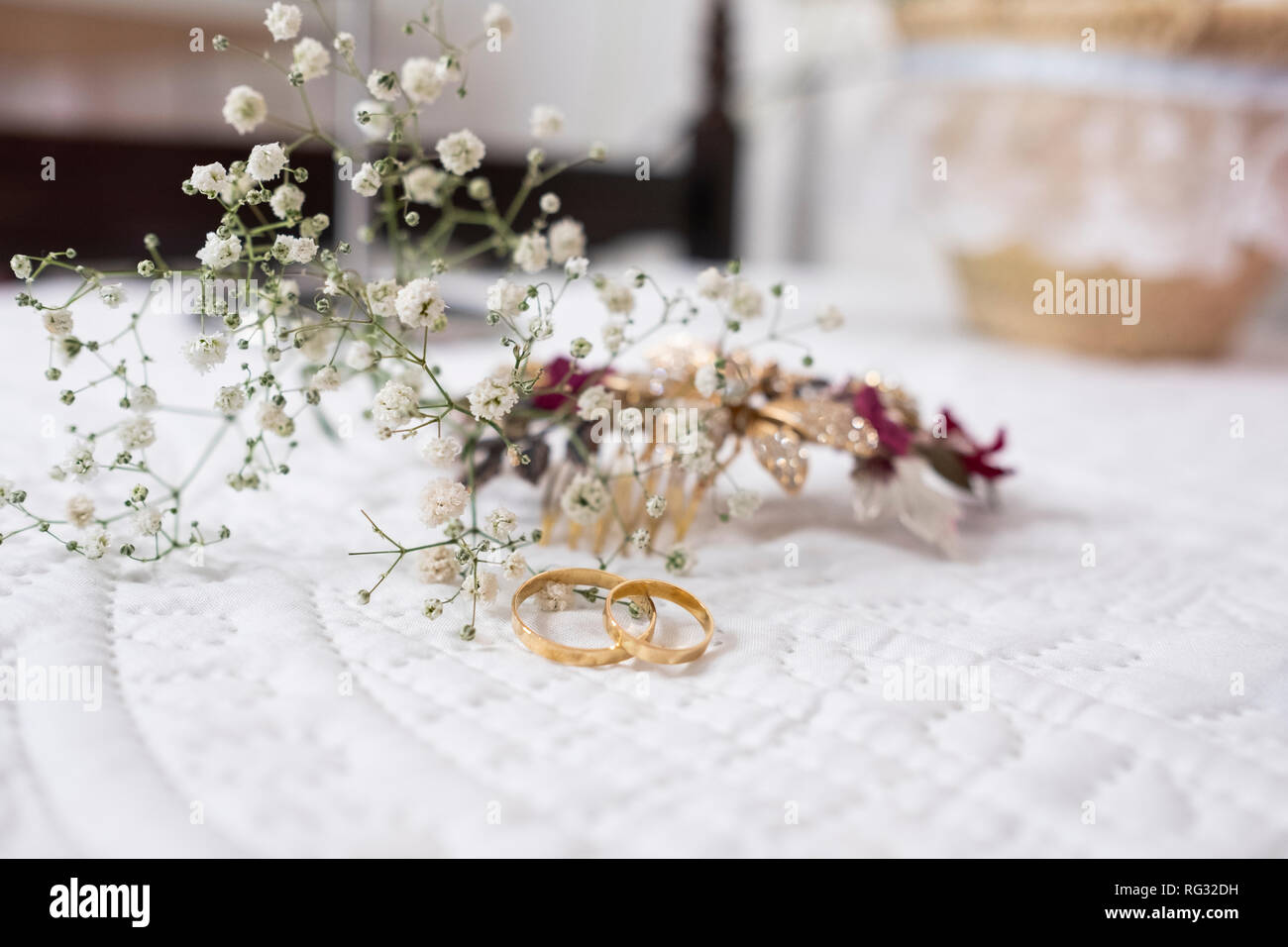 Gli anelli di fidanzamento per un matrimonio con fiori dietro Foto Stock