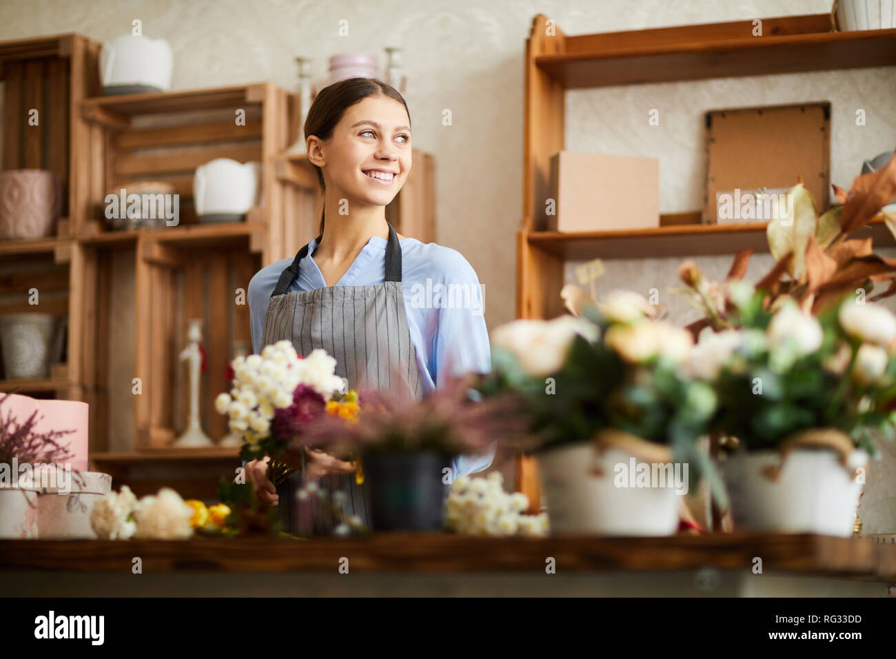 Donna sorridente a lavorare nel negozio di fiori Foto Stock