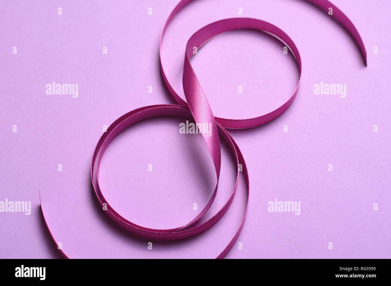8 marzo, Giornata internazionale della donna biglietto di auguri, viola del nastro nella forma a 8, celebrazione Concept Foto Stock