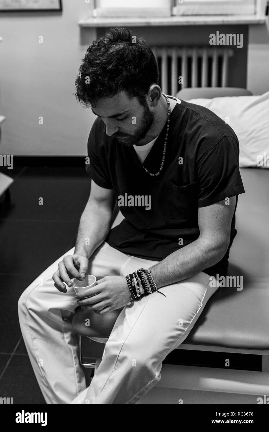 Un bianco uomo italiano, lavorando come un phisiotherapist è fotografato mentre si è al lavoro per tutto il dat in un ospedale in Italia. Foto Stock