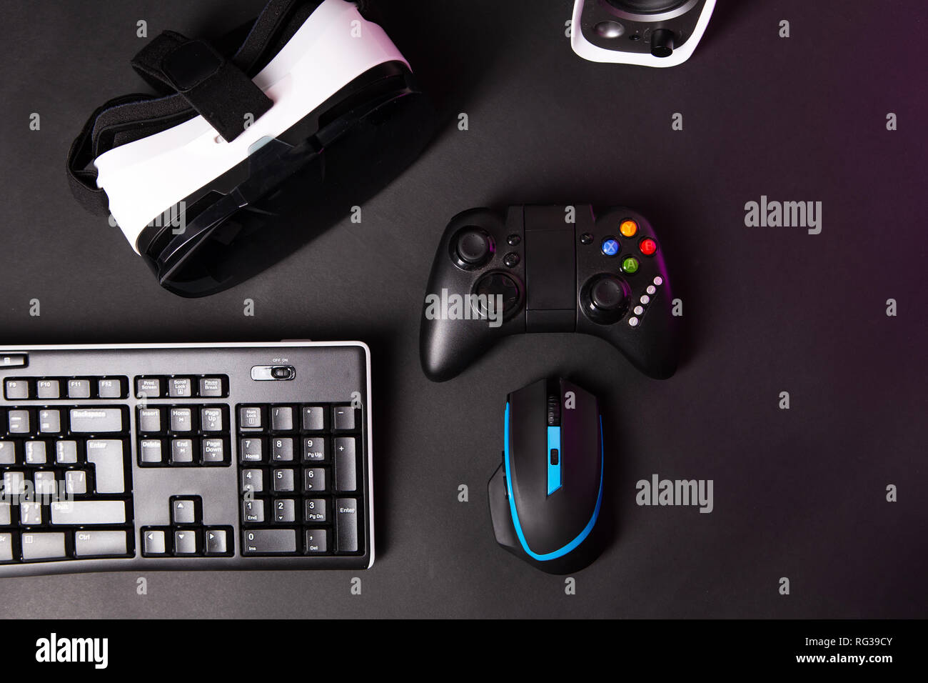 Vista dall'alto di un ingranaggio di gioco, mouse, tastiera, joystick, la  cuffia auricolare VR nero su sfondo tabella. Gamer concetto di area di  lavoro Foto stock - Alamy