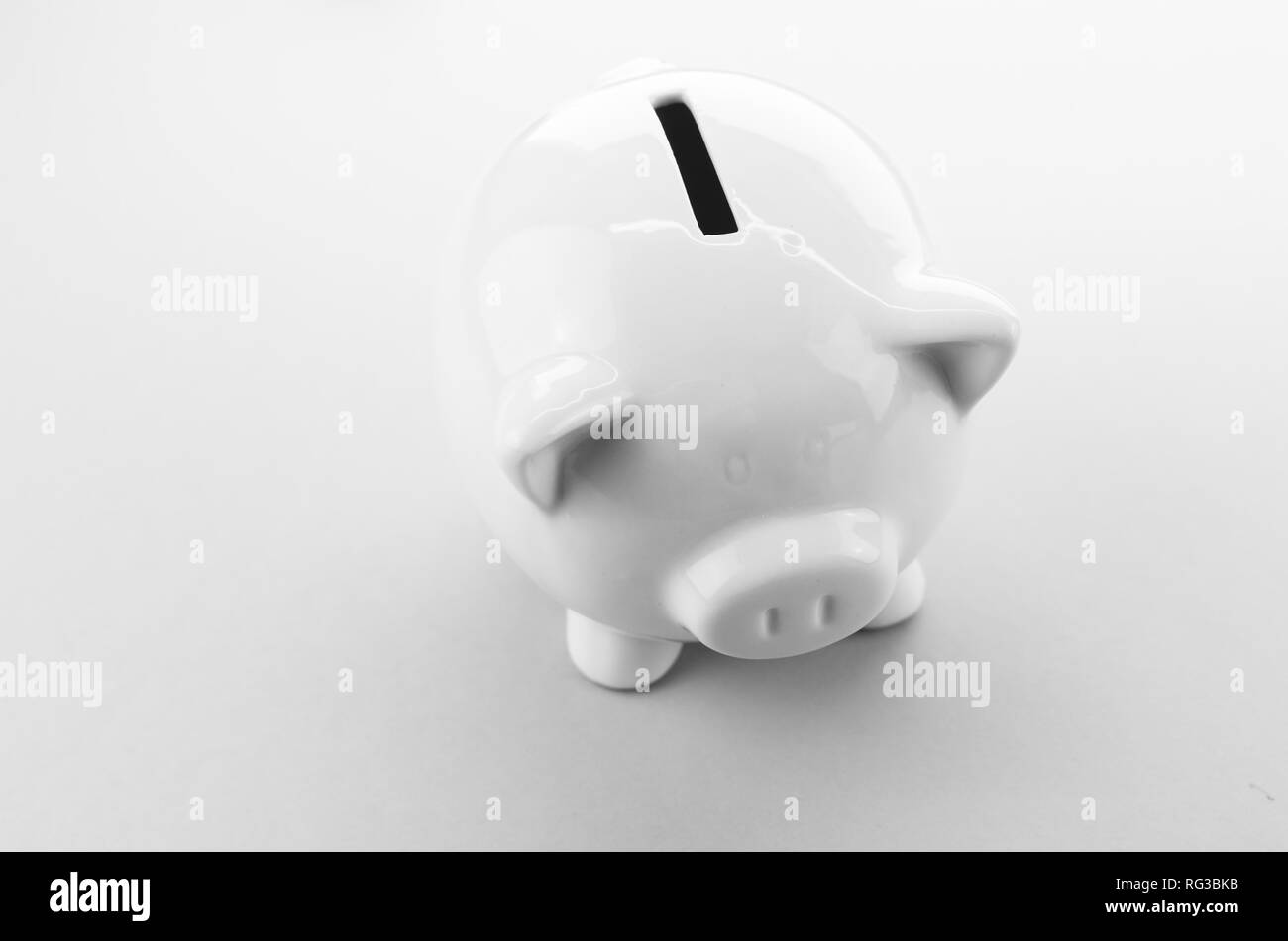 Salvadanaio su una superficie bianca - Investimenti e concetto di risparmio Foto Stock