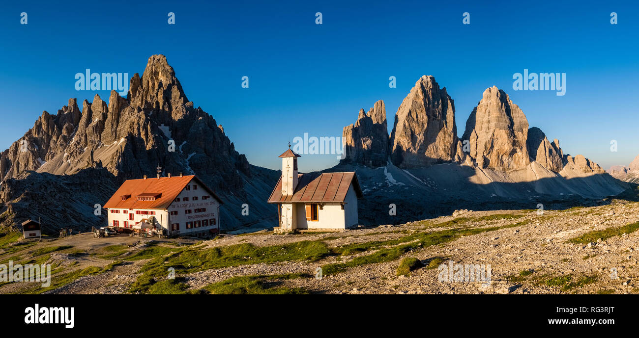 Vista panoramica sulle montagne del gruppo Tre Cime di Lavaredo e Paternkofel, Monte Paterno, all'alba, con il rifugio tre merlato capanna e un piccolo Foto Stock