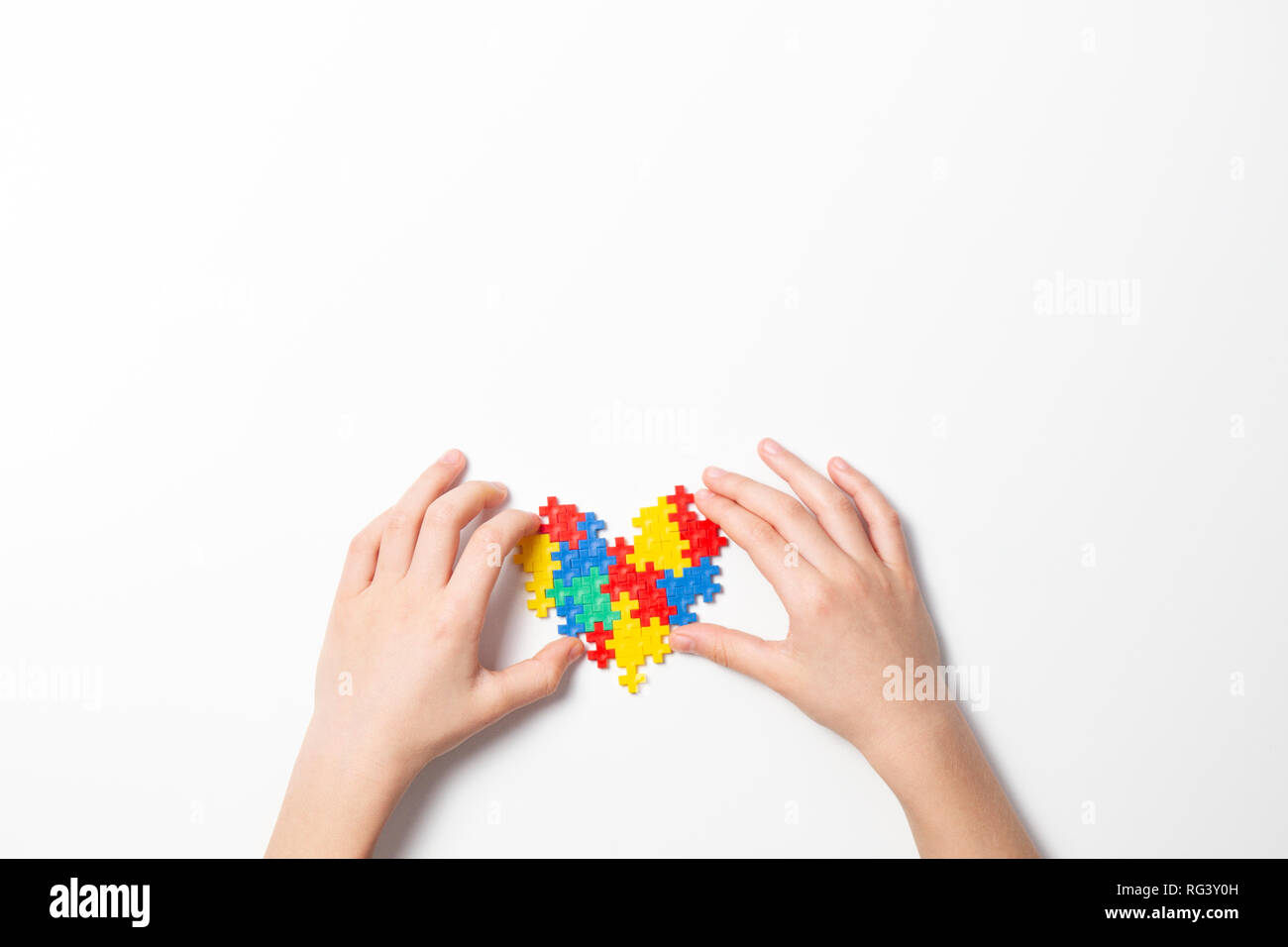 Bambino mani cuore colorato su sfondo bianco. Mondo autismo consapevolezza giorno di concetto Foto Stock