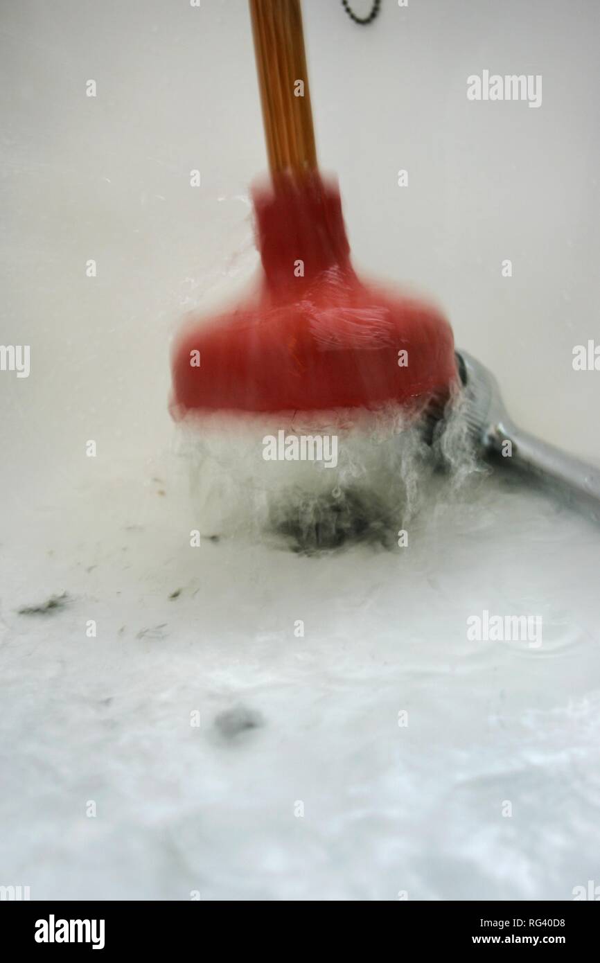 DEU, Germania : addetti alle pulizie hanno in una casa privata/appartamento. Pulizia di un deflusso bloccato in una vasca da bagno. Foto Stock