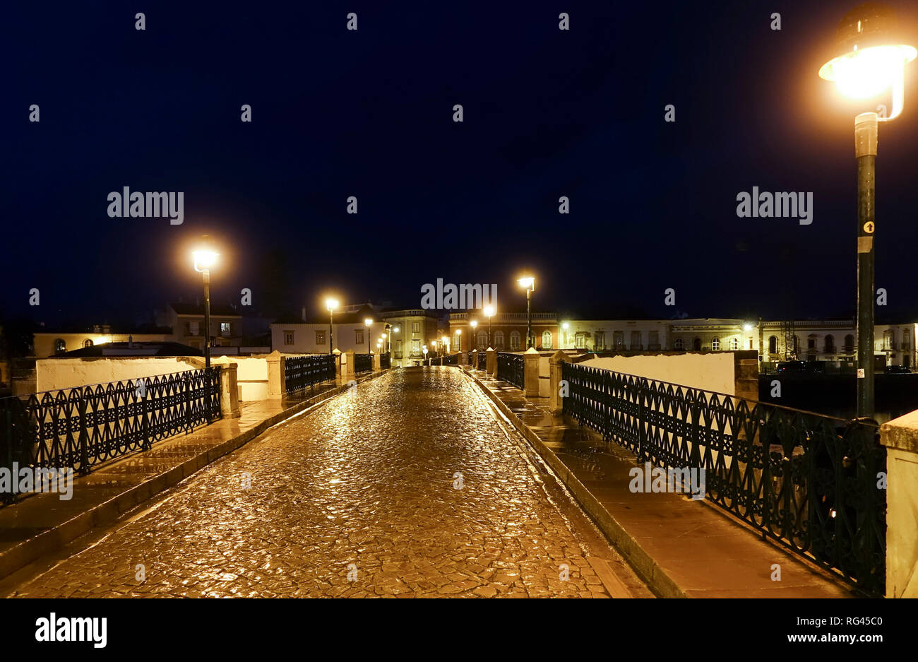 Tavira, Portogallo, la strada pedonale di ponte romano spanning, fiume Gilão della cittadina di pescatori, Tavira durante la notte, Algarve, Portogallo, dell'Europa. Foto Stock