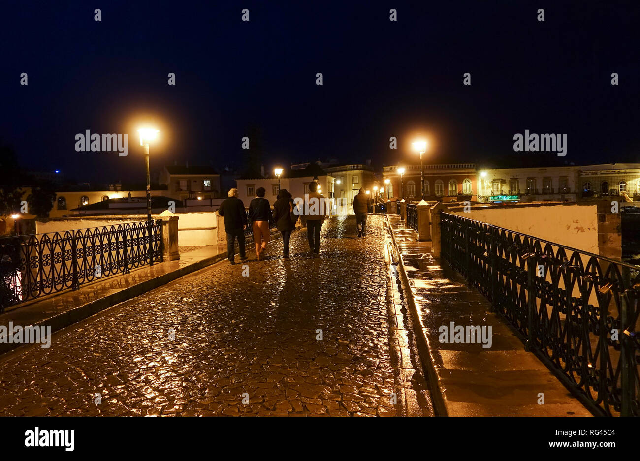 Tavira, Portogallo, la strada pedonale di ponte romano spanning, fiume Gilão della cittadina di pescatori, Tavira durante la notte, Algarve, Portogallo, dell'Europa. Foto Stock