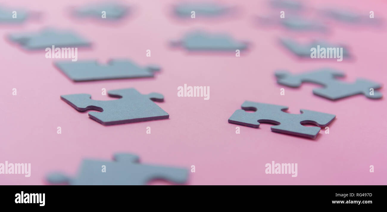 Puzzle di carta su un sfondo rosa Foto Stock