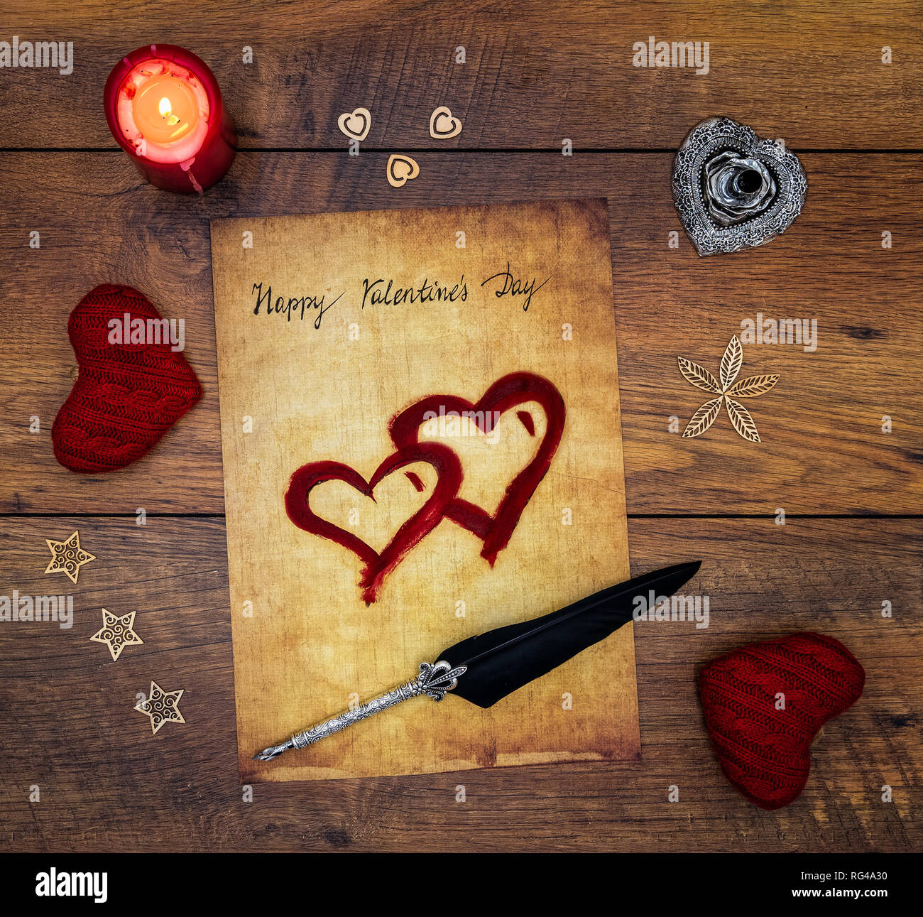 Classic Buon San Valentino carta scritta a mano su carta pergamena 2 dipinte di rosso cuore candela rossa decorazioni color argento e del cappello del supporto sul rovere vintage vista superiore Foto Stock