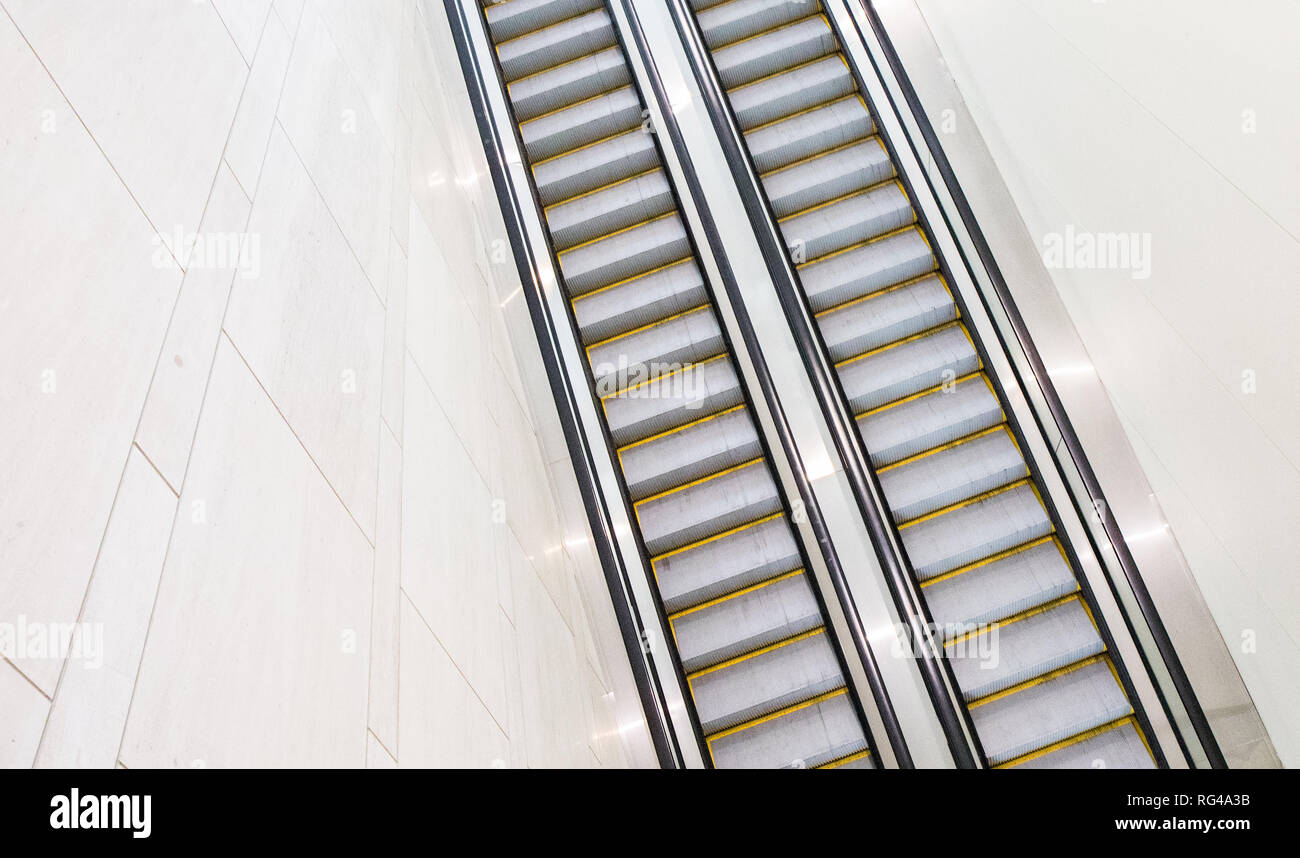 Entrambi i set di su e giù per le scale mobili di un hotel centro congressi con nessuno li equitazione. e escaltors giù in un hotel centro congressi con nessuno Foto Stock