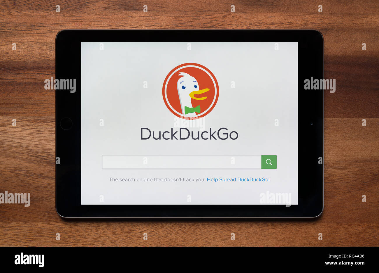 Il sito web di DuckDuckGo è visto su un tablet iPad, il quale è appoggiato su un tavolo di legno (solo uso editoriale). Foto Stock