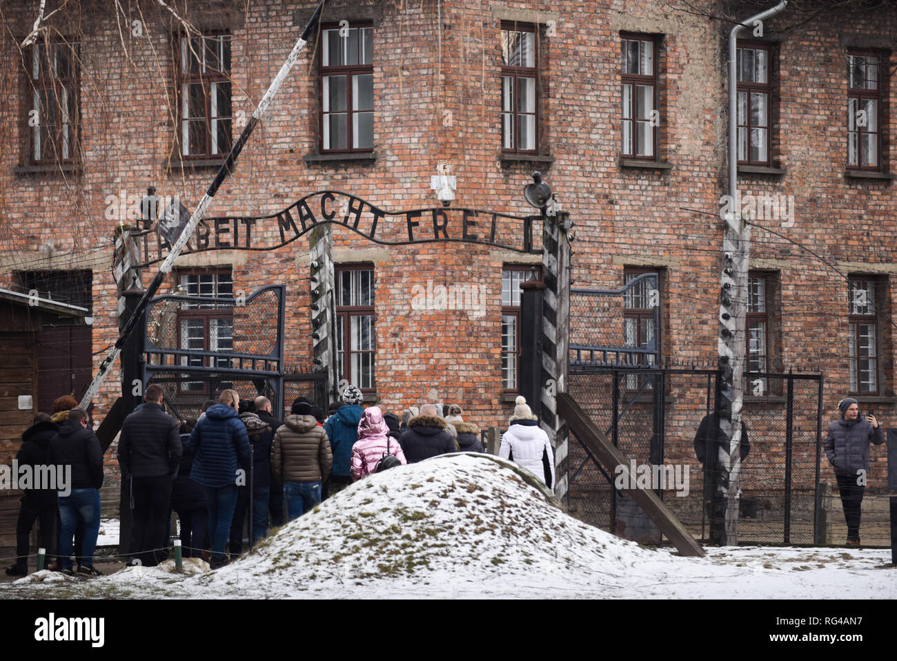 I visitatori sono visto che attraversa la famosa Porta del camp durante 74anniversario della liberazione di Auschwitz e l'olocausto Giorno del Ricordo. Il tedesco più grande campo di lavoro e sterminio nazista KL Auschwitz-Birkenau fu liberata da parte dell'Armata Rossa il 27 gennaio 1945. Foto Stock