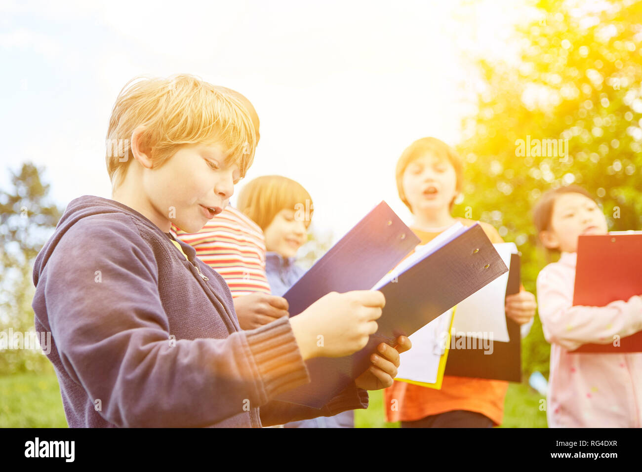 I bambini con appunti giocare a caccia al tesoro al compleanno di bambini in estate Foto Stock