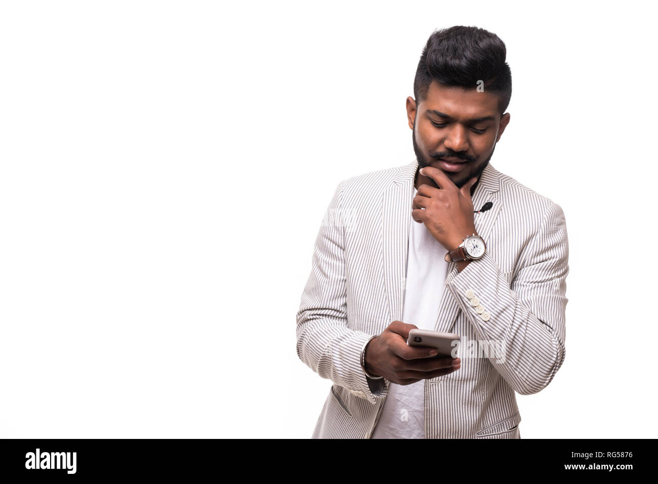 Bello tanga indiano uomo barba utilizza lo smartphone in mano isolati su sfondo bianco Foto Stock