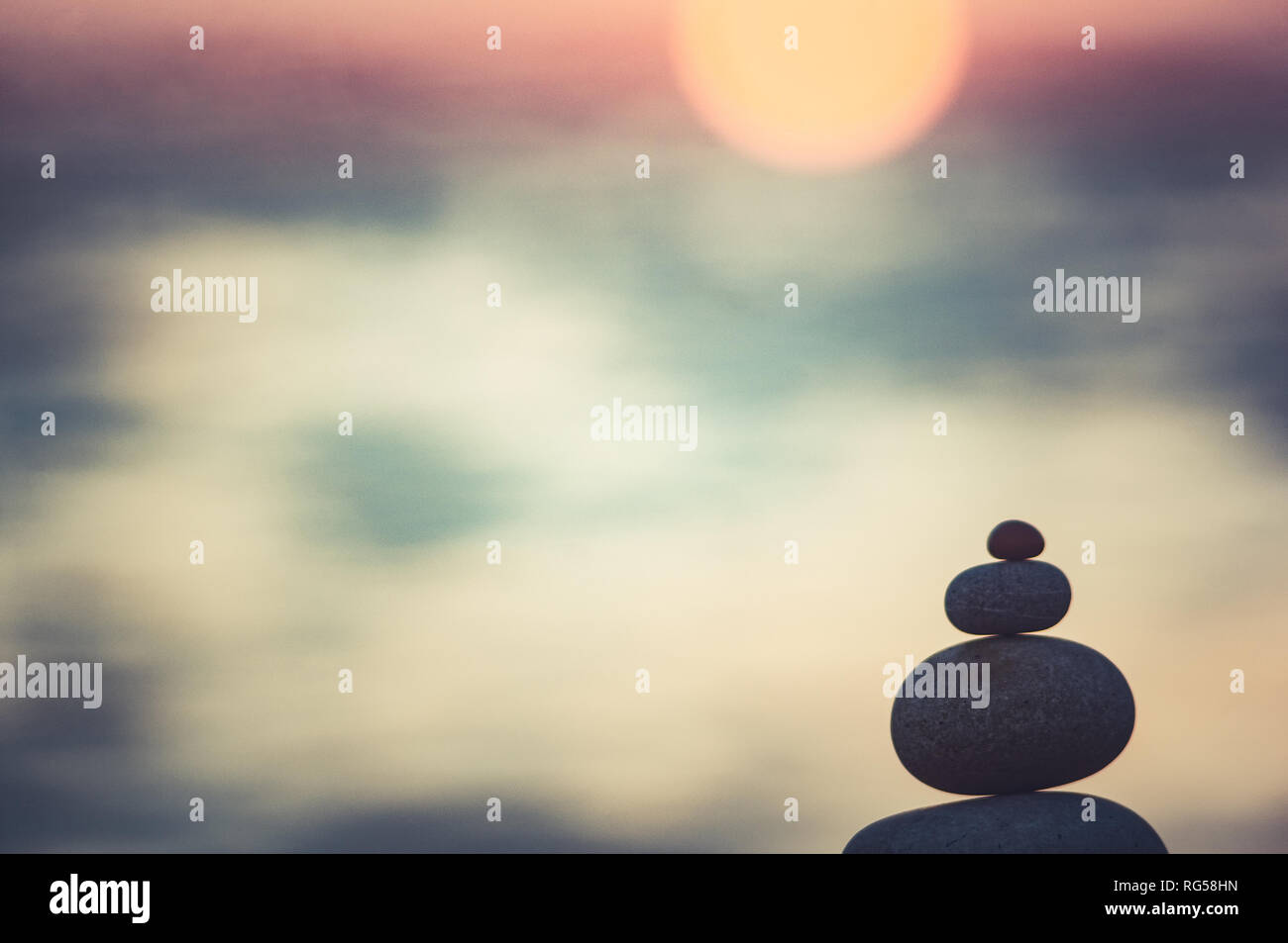 Piramide piegata Zen pietre ghiaia sul mare spiaggia al tramonto Foto Stock