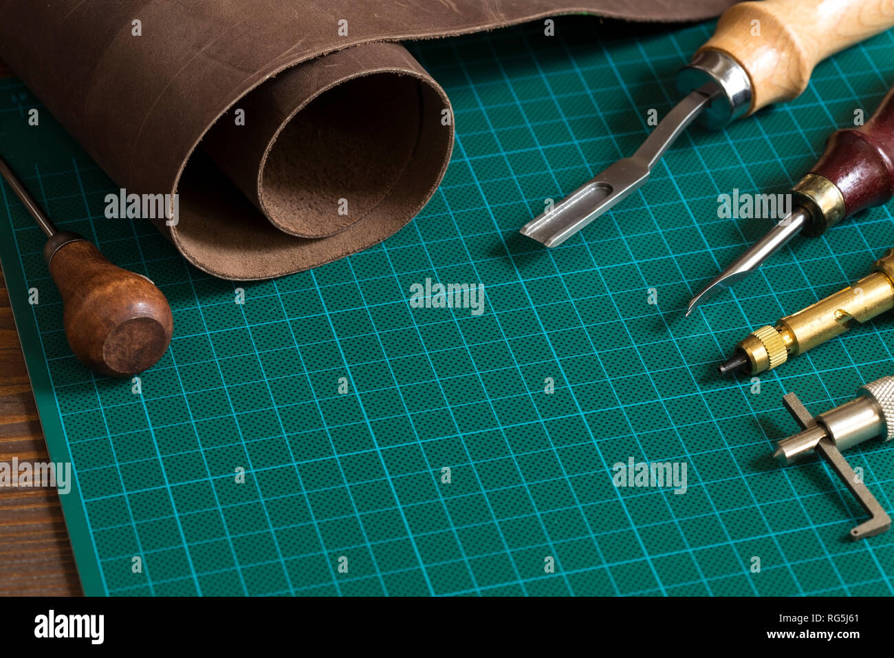 Artigianali in pelle strumenti sul tappeto di taglio Foto Stock