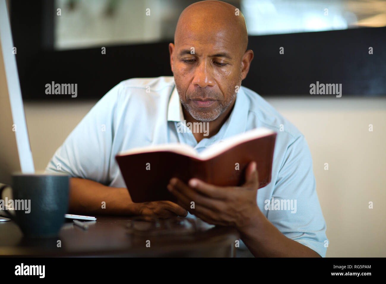 African American uomo pregare e leggere la Bibbia. Foto Stock