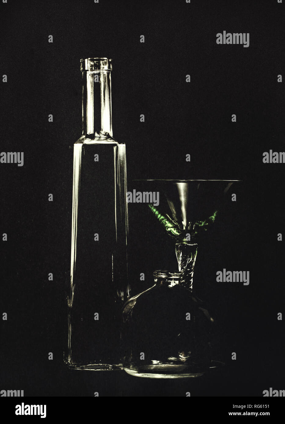 Bottiglie vuote e un bicchiere da cocktail, veleno, omicidio concetto. Così retroilluminato con sfondo nero, artistico texture applicata. Foto Stock