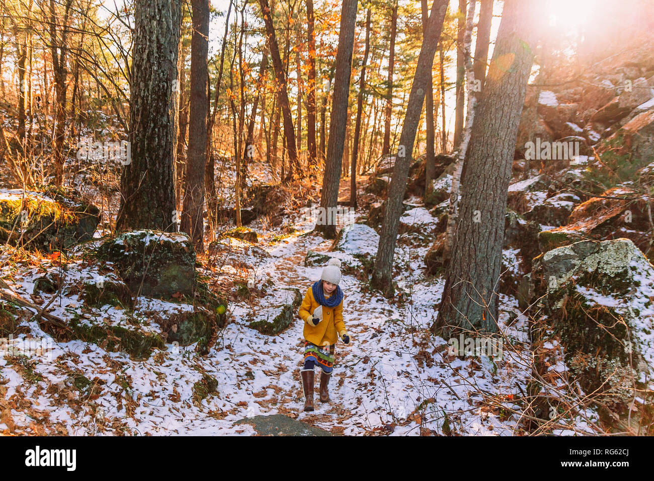 Ragazza escursionismo attraverso la foresta, tenendo in mano un pezzo di ghiaccio congelato, Stati Uniti Foto Stock
