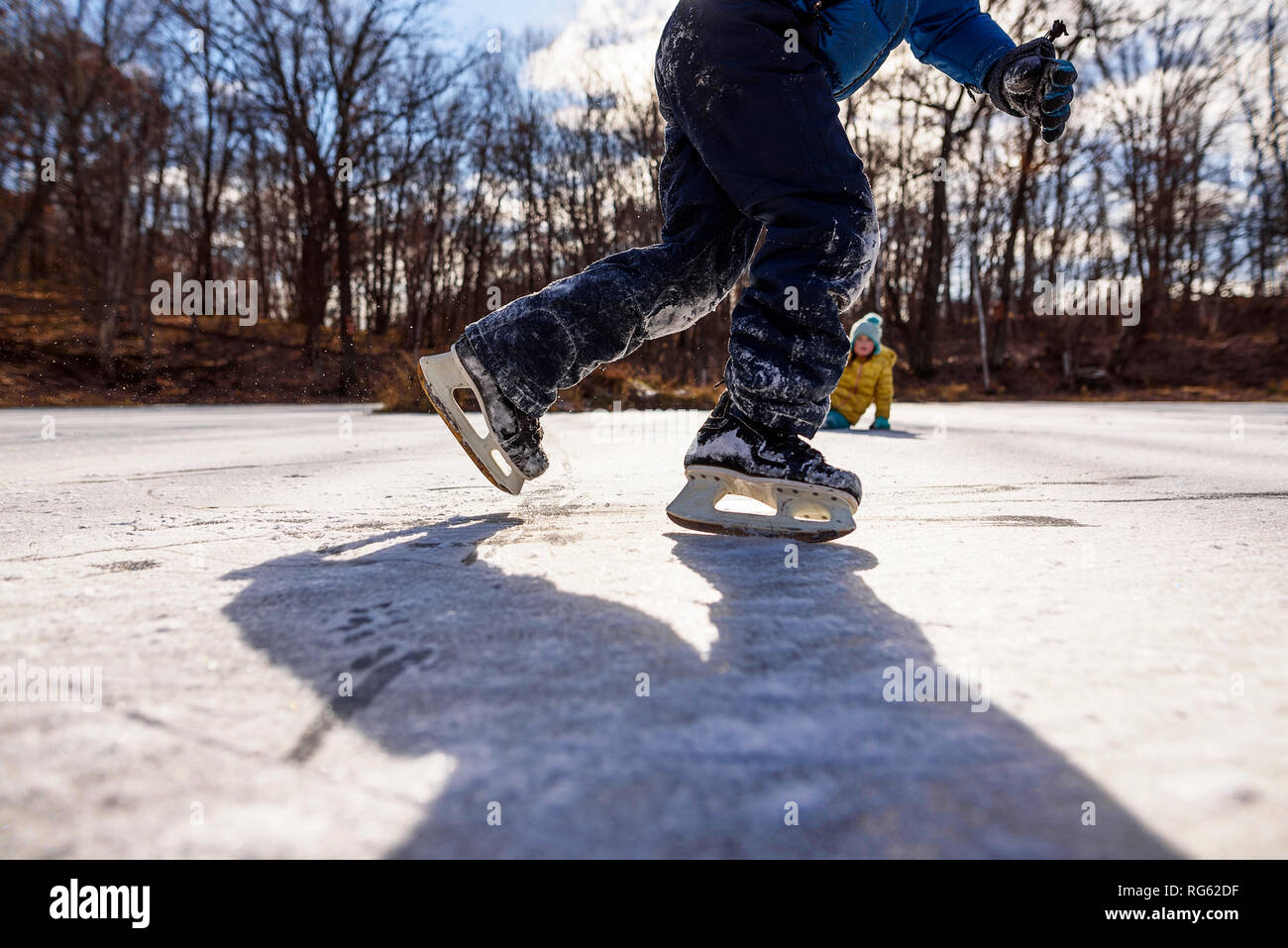 Due bambini di pattinaggio su ghiaccio su un laghetto congelato, Stati Uniti Foto Stock