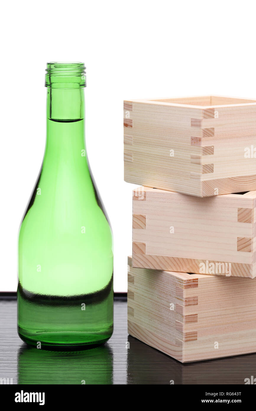 Sake Giapponese bottiglia con scatola di legno masu su un tavolo sfondo bianco Foto Stock
