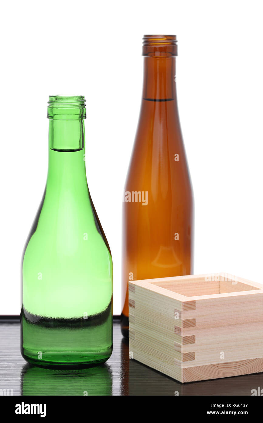 Sake Giapponese bottiglia con scatola di legno masu su un tavolo sfondo bianco Foto Stock