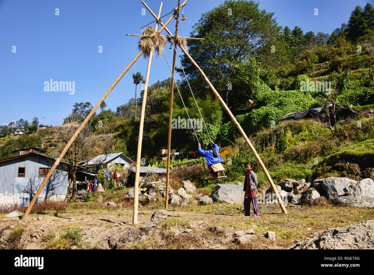 Bambini che giocano su un ping di bambù Swing sul sentiero per il Campo Base Everest, Khumbu, in Nepal Foto Stock