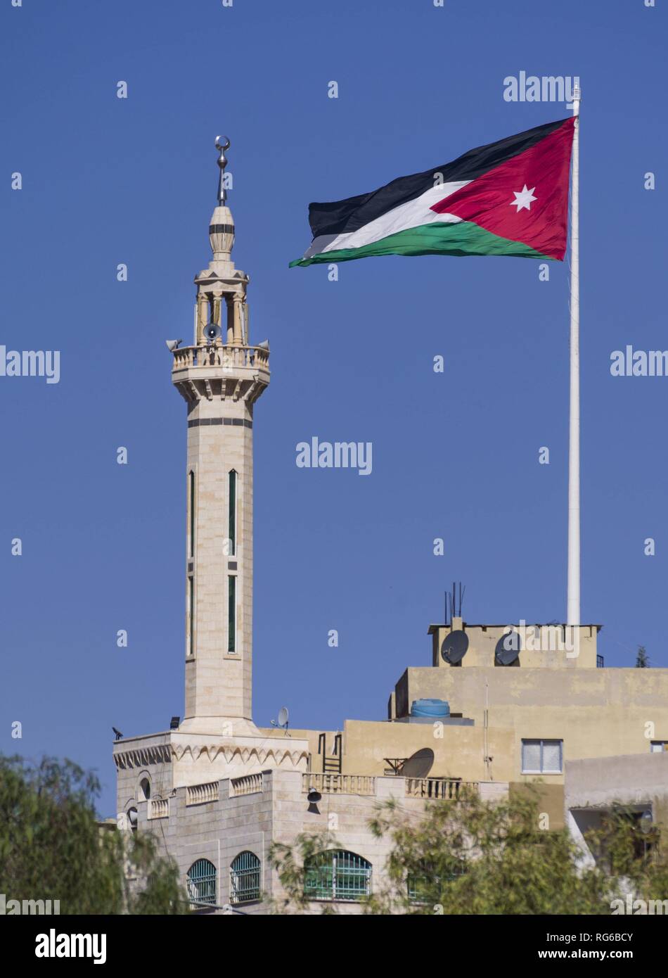 Proprio accanto a un minareto della Giordania bandiera nazionale sembra flutter sopra la città vecchia di Amman. Infatti i 1.800 metri quadrati bandiera gigante si trova su di un misuratore di 126.8 montante di alta. (02 novembre 2018) | utilizzo in tutto il mondo Foto Stock