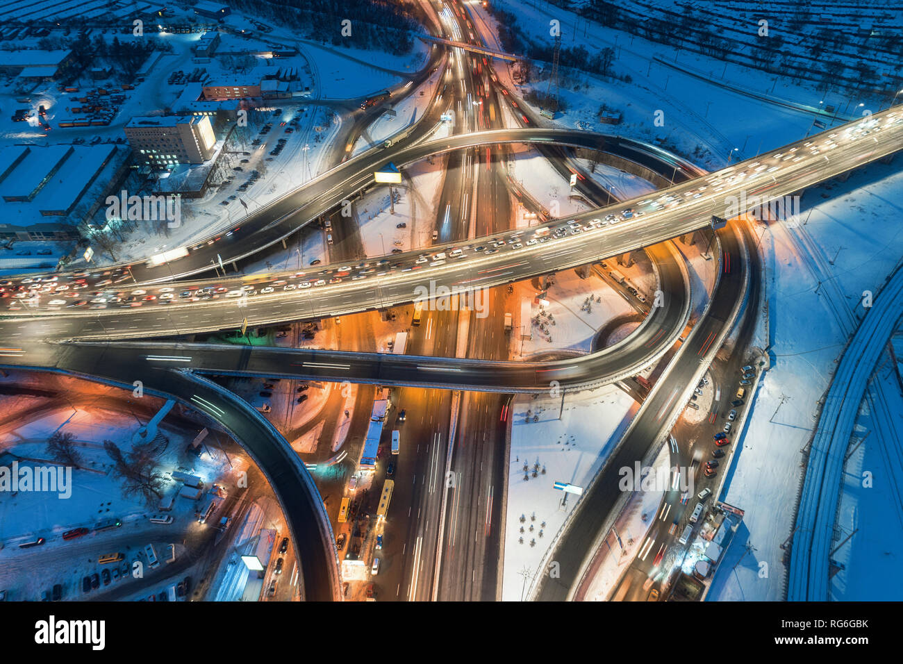 Vista aerea di strada nella città moderna in una notte d'inverno. Vista superiore del traffico in autostrada con illuminazione. Strada Sopraelevata e interscambio ov Foto Stock