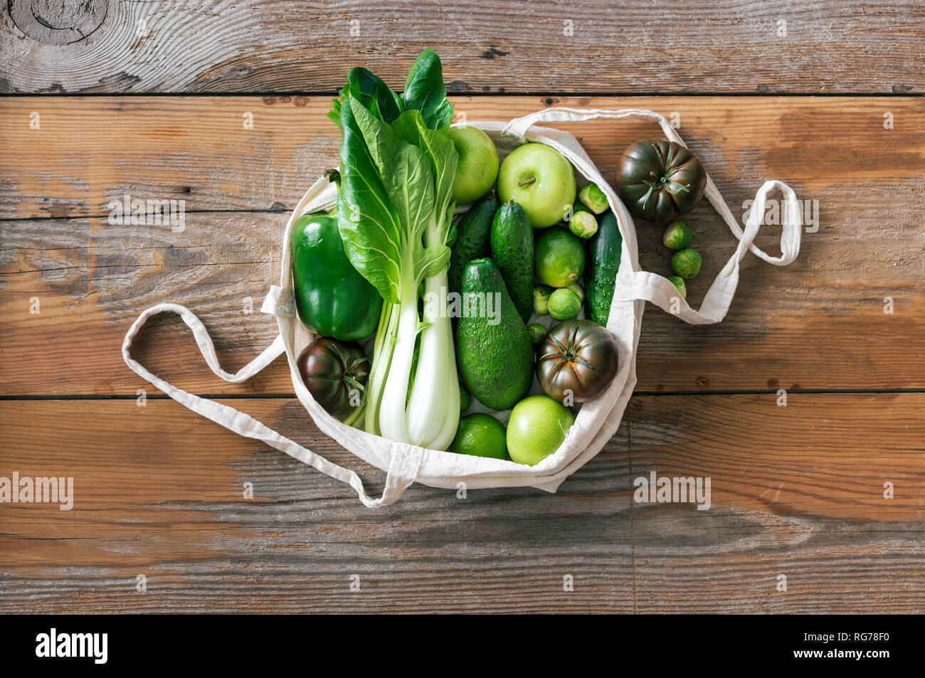 Fresco cibo organico la frutta e la verdura in tessuto Eco borsa. Vegetariano o Vegano cibo su sfondo di legno Top View Flat Lay Foto Stock