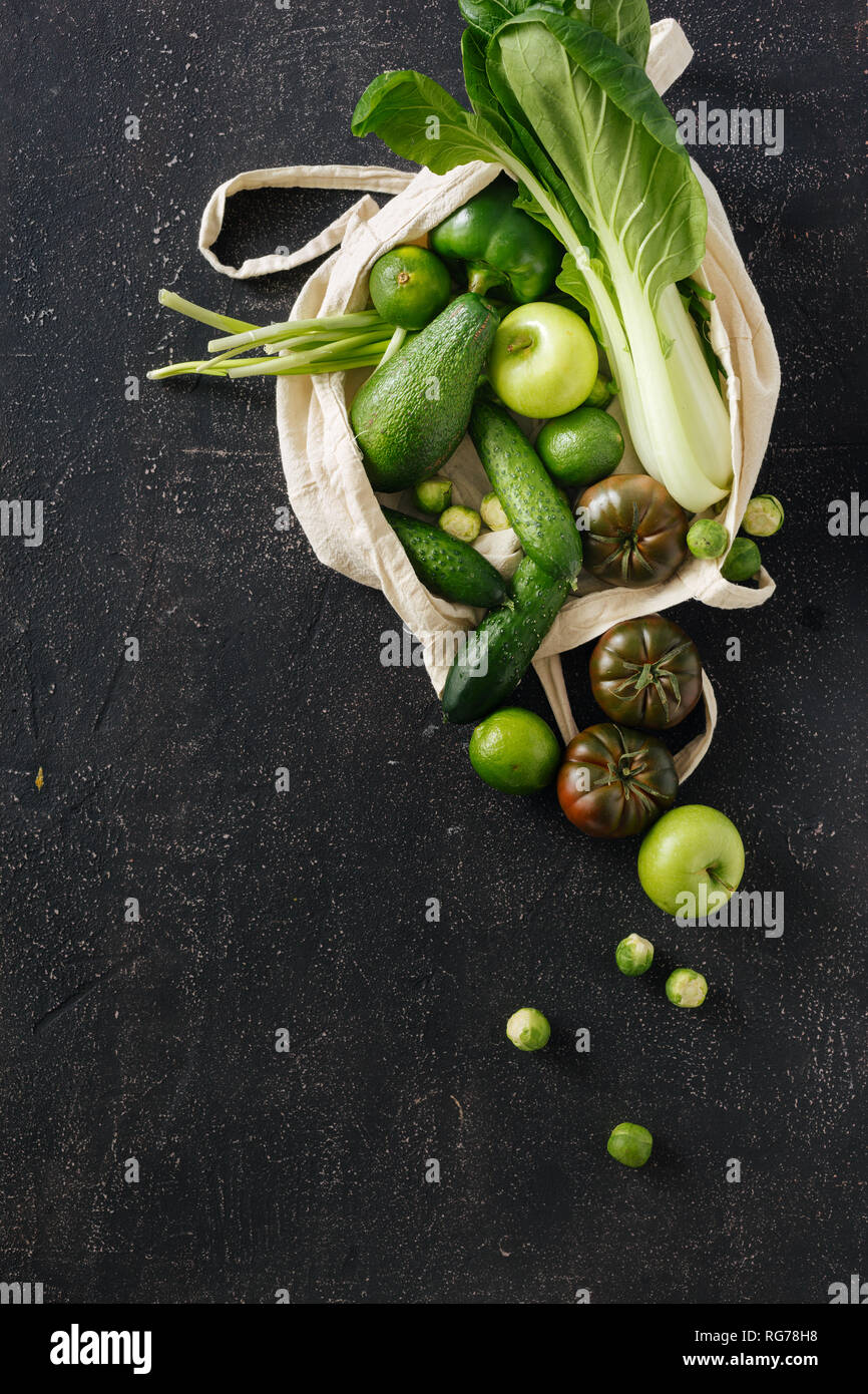 Fresco cibo organico la frutta e la verdura in tessuto Eco borsa. Vegetariano o Vegano cibo su sfondo scuro Top View Flat Lay Foto Stock