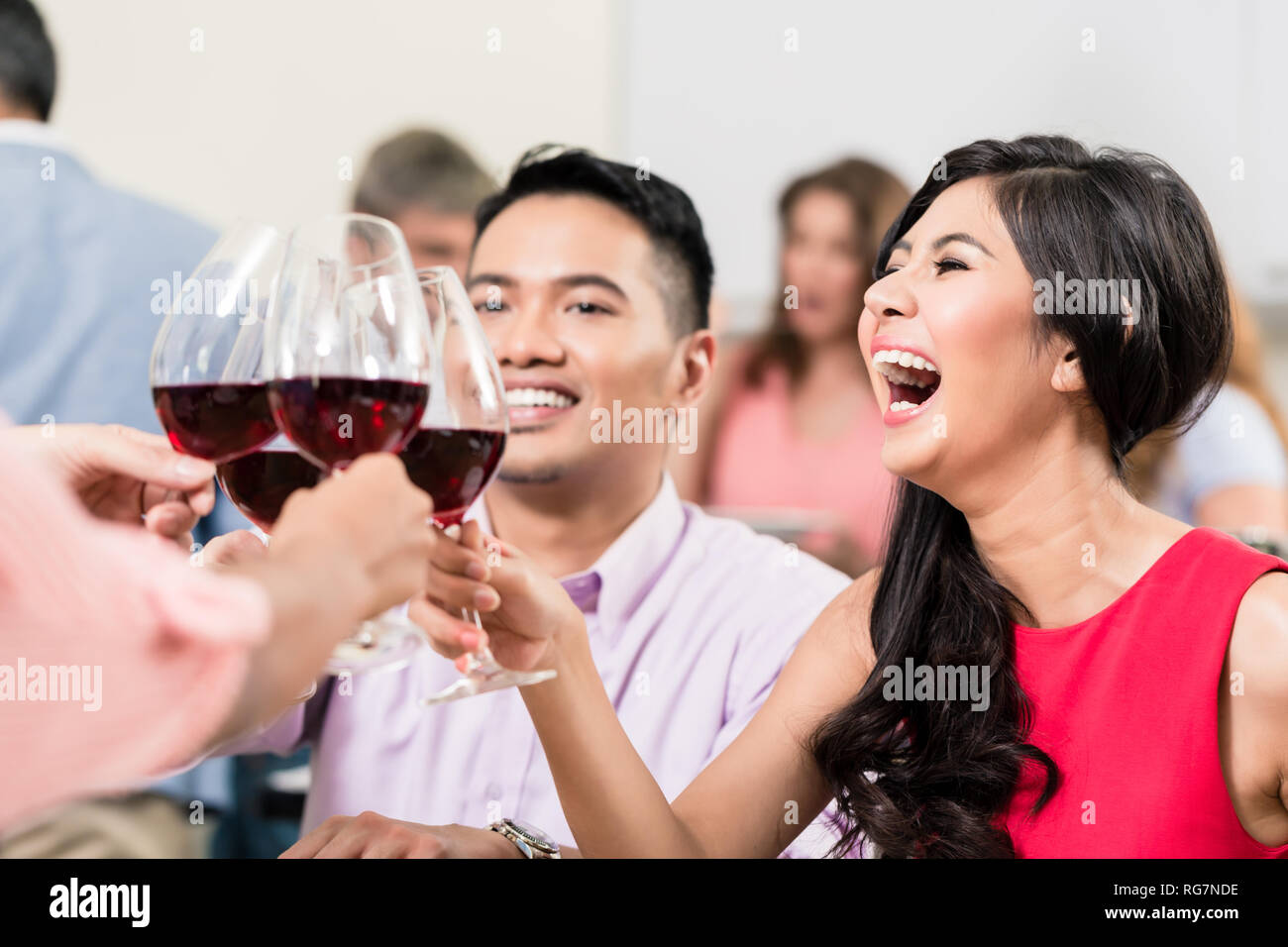 Donna wineglasses tostatura con gli amici Foto Stock