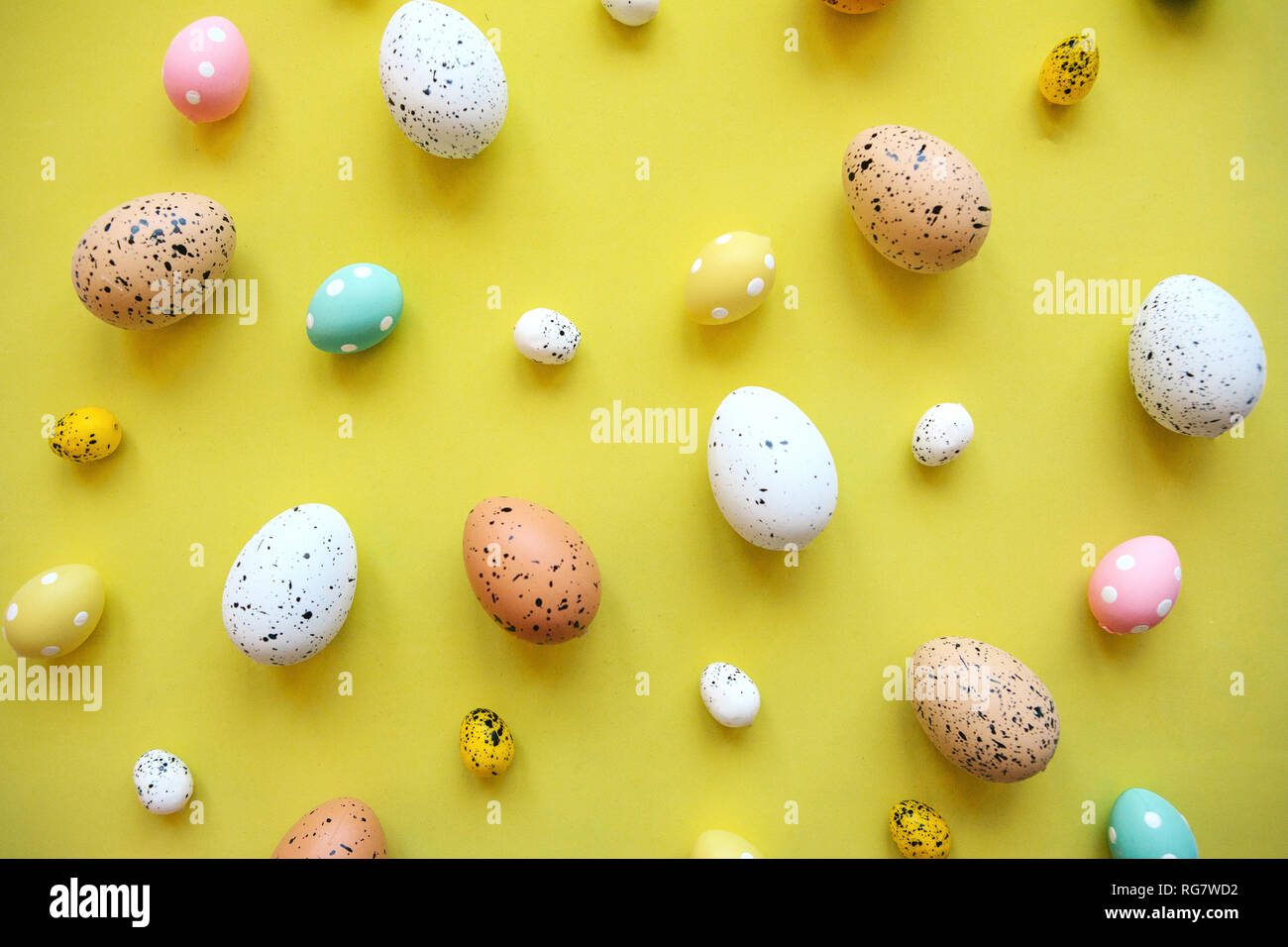 Un sacco di colorate uova di Pasqua su sfondo giallo. Pasqua Festa dello sfondo. Foto Stock