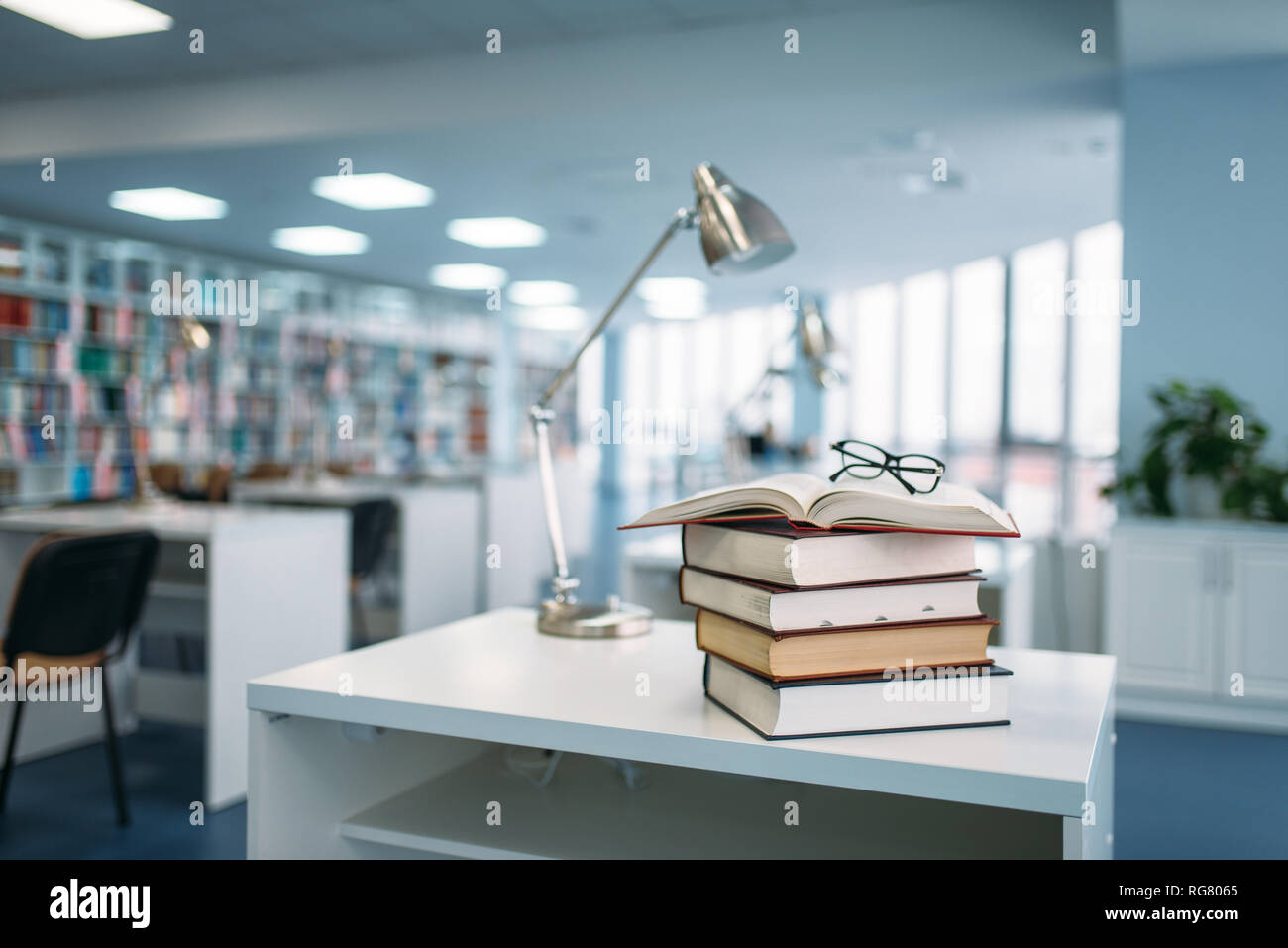 Pila di libri e i bicchieri sul tavolo della biblioteca universitaria, nessuno. Depositario della conoscenza, istruzione Foto Stock