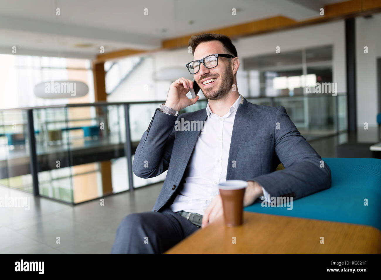 Pensieroso giovane imprenditore nel cafe usando il telefono Foto Stock