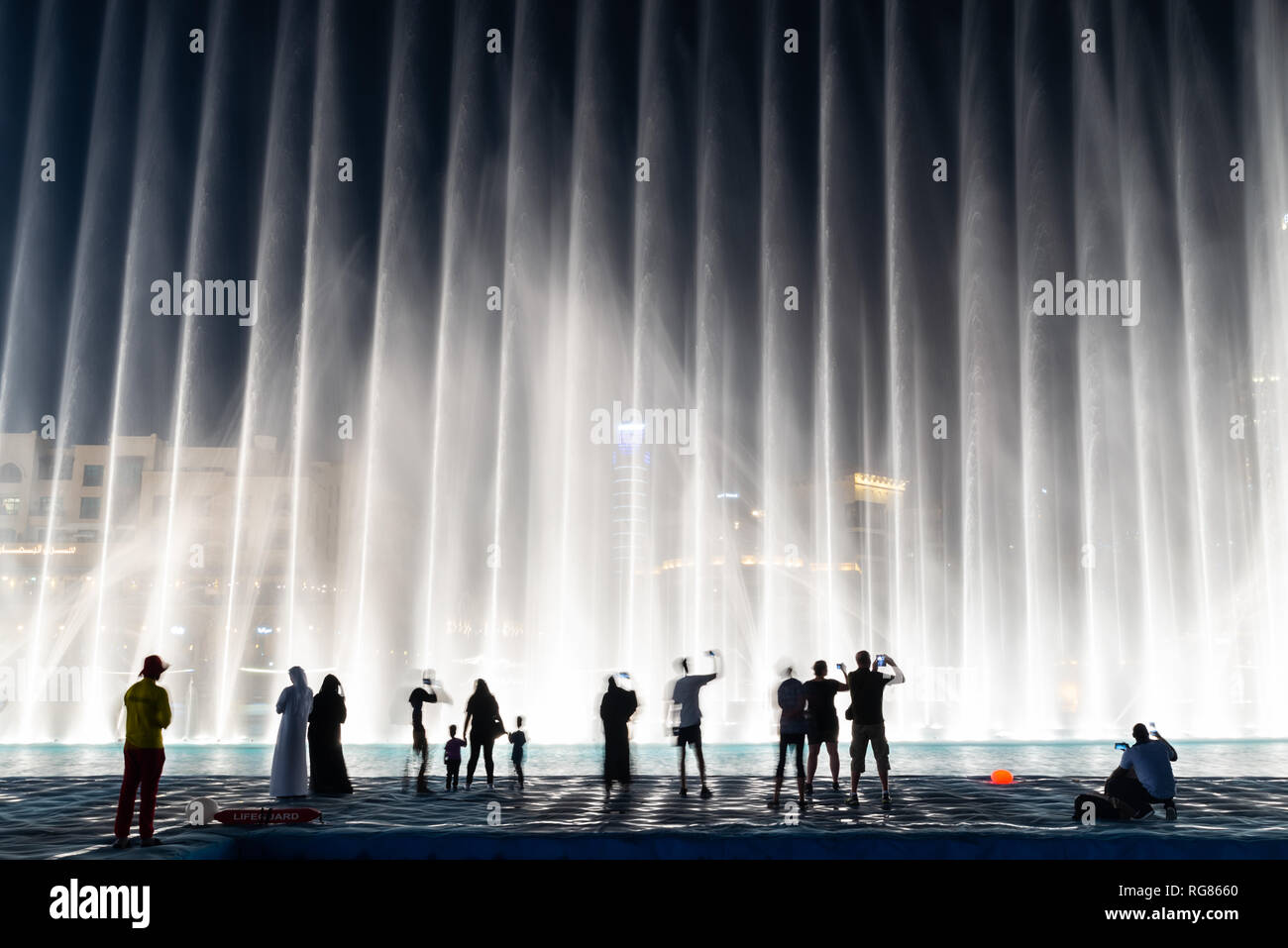 Sagome di persone godendo la fontana show di Dubai di notte, Emirati Arabi Uniti Foto Stock