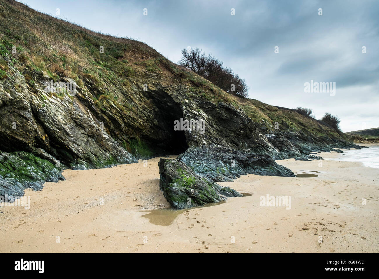 Una grotta nella roccia esposta a bassa marea presso l'appartato Polly Porth scherzo beach in Newquay Cornwall. Foto Stock