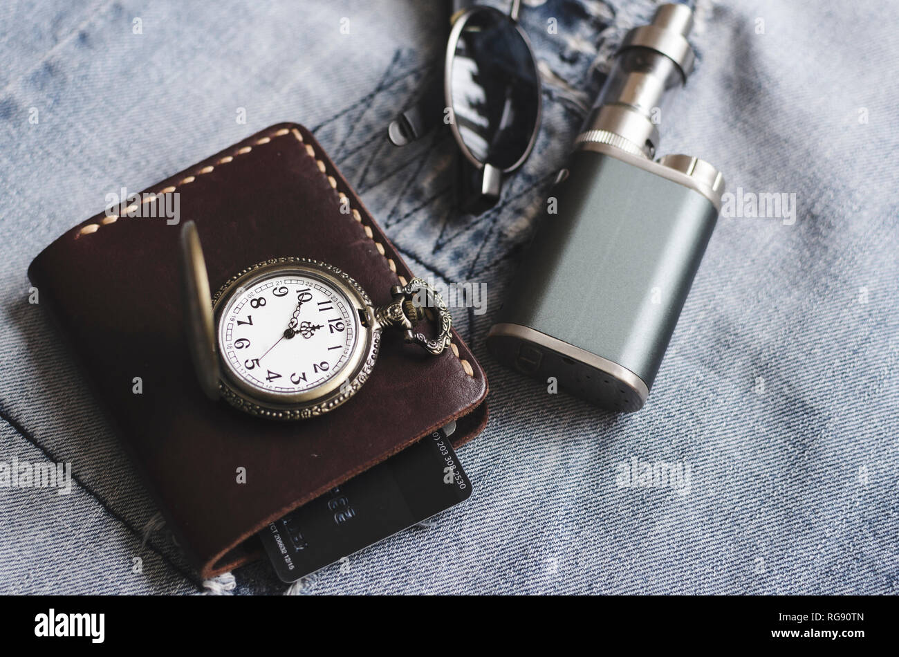 Uomo accessori, guarda, portafoglio, e sigarette e bicchieri in jeans blu Foto Stock