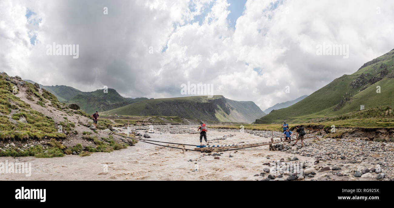 La Russia, il Caucaso, gli alpinisti Varcando il fiume in Alta Valle Baksan Foto Stock