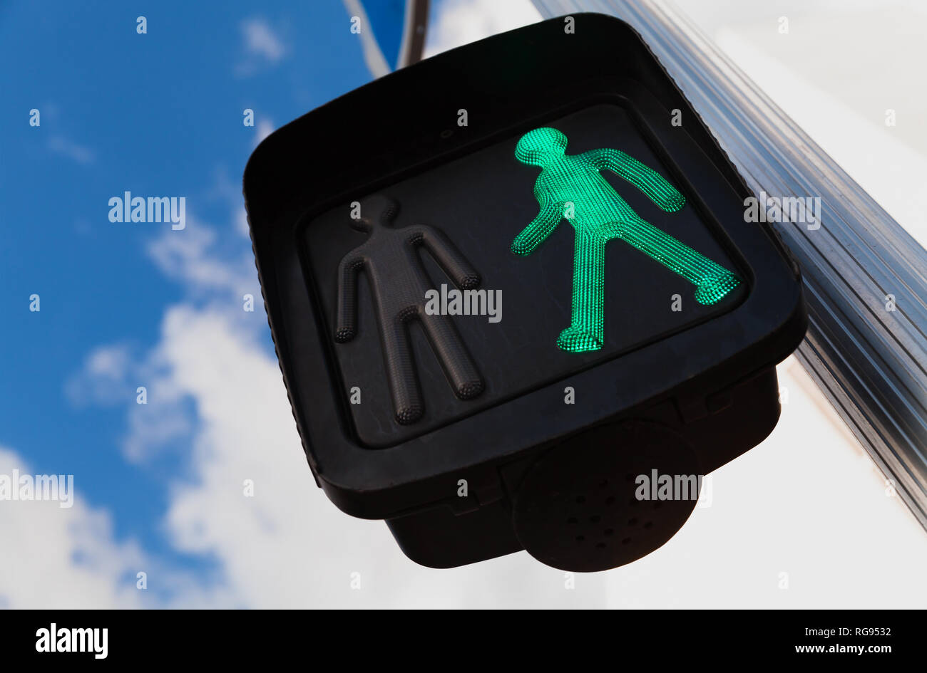 Attraversamento pedonale semaforo sotto il blu cielo nuvoloso visualizza verde segnale permettono di andare Foto Stock